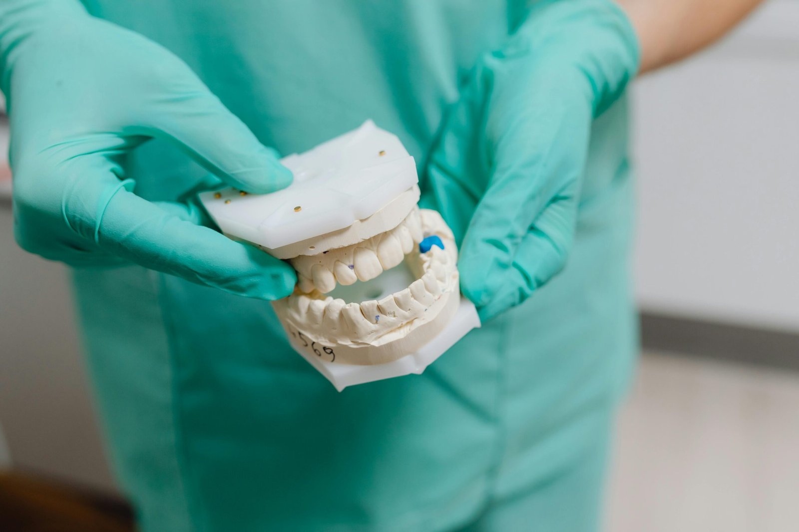 Persona limpiando su prótesis dental con cepillo suave – cómo cuidar tu prótesis dental correctamente.